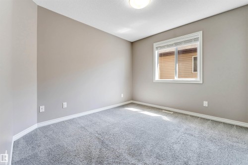 Neutral wall paint, light gray carpet flooring, white baseboards, and a white-framed window with blinds - 2138 32B Street, Edmonton, AB - Indoor Photo Showing Other Room