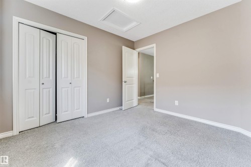 Spacious room featuring neutral carpeting, light gray wall paint, and white trim - 2138 32B Street, Edmonton, AB - Indoor