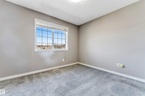 Carpeted room with a multi-pane window and neutral wall paint - 2138 32B Street, Edmonton, AB - Indoor Photo Showing Other Room
