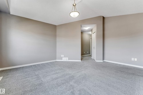 Spacious room featuring neutral grey walls and a light grey carpeted floor - 2138 32B Street, Edmonton, AB - Indoor Photo Showing Other Room