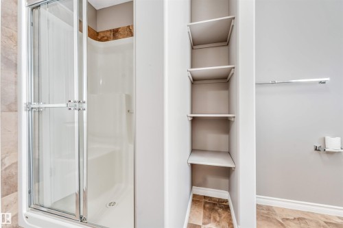 Shower with glass enclosure, white basin, and brown tile accent - 2138 32B Street, Edmonton, AB - Indoor Photo Showing Bathroom