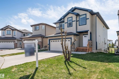 Two-story residence featuring light-colored siding with dark blue trim accents and a contrasting dark roof - 2138 32B Street, Edmonton, AB - Outdoor With Facade