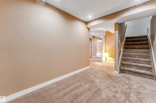 Carpeted staircase with a metal handrail - 2138 32B Street, Edmonton, AB - Indoor Photo Showing Other Room