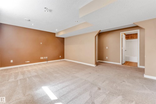 Expansive carpeted room featuring recessed lighting, a dropped ceiling detail, and access to a bathroom with tile flooring and a tub - 2138 32B Street, Edmonton, AB - Indoor Photo Showing Other Room