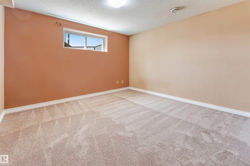 Carpeted room featuring a window with exterior railing, neutral-toned walls, and white baseboards - 2138 32B Street, Edmonton, AB - Indoor Photo Showing Other Room