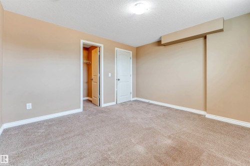 Carpeted interior space featuring neutral wall tones, white trim, and a flush mount ceiling light - 2138 32B Street, Edmonton, AB - Indoor Photo Showing Other Room