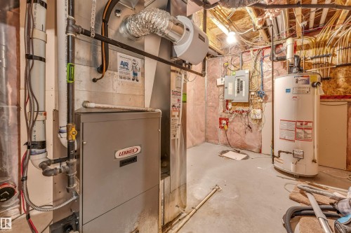 Utility room featuring a Lennox furnace, water heater, electrical panel, exposed ceiling joists, and insulated walls - 2138 32B Street, Edmonton, AB - Indoor Photo Showing Basement