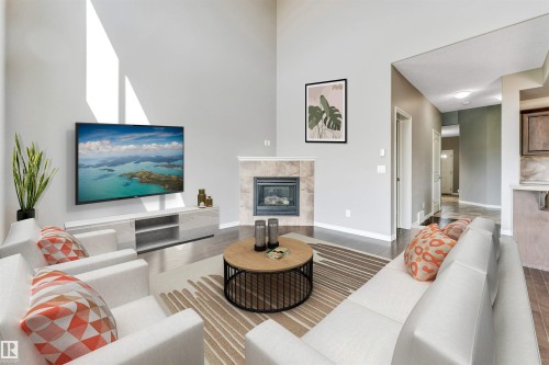 Spacious living area featuring a vaulted ceiling and dark wood-finish flooring - 2138 32B Street, Edmonton, AB - Indoor Photo Showing Living Room With Fireplace