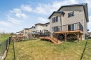 Rear exterior featuring a multi-level wooden deck with black metal railings and stairs - 2138 32B Street, Edmonton, AB  - Outdoor With Deck Patio Veranda 