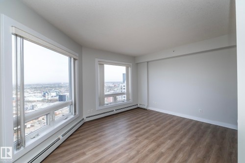 Spacious room with wood-finish flooring and white baseboards - 3104 10152 104 Street, Edmonton, AB - Indoor Photo Showing Other Room