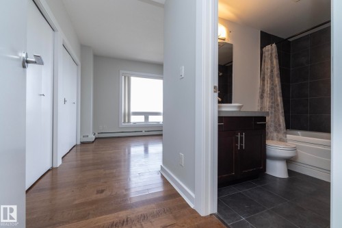 Hardwood-finish flooring throughout, complemented by light gray walls and white trim - 3104 10152 104 Street, Edmonton, AB - Indoor