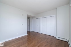 Room featuring wood-finish flooring, light-toned wall paint, and white baseboards - 