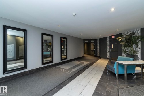 Contemporary lobby featuring mixed-material flooring with light and dark tiles, recessed lighting, and a textured wall with geometric patterns - 3104 10152 104 Street, Edmonton, AB - Indoor Photo Showing Other Room