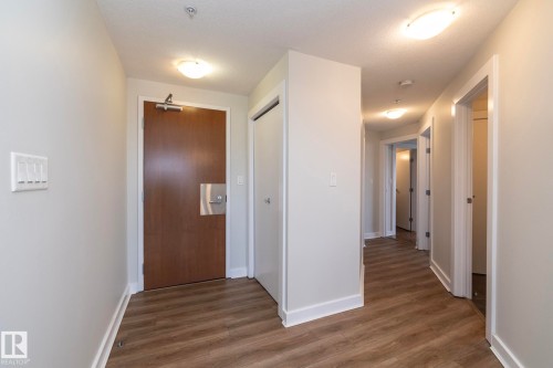 Entry foyer featuring wood-finish flooring, light grey painted walls, and white baseboards - 3104 10152 104 Street, Edmonton, AB - Indoor Photo Showing Other Room