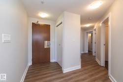 Entry foyer featuring wood-finish flooring, light grey painted walls, and white baseboards - 
