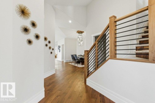 Entryway featuring wood-finish flooring, a contemporary staircase with wood railing and black metal spindles, and a vaulted ceiling - 1 Sparrow Close, Fort Saskatchewan, AB - Indoor Photo Showing Other Room