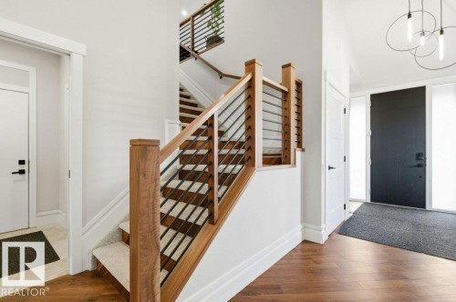 Foyer featuring a contemporary wood and metal staircase with carpeted treads - 1 Sparrow Close, Fort Saskatchewan, AB - Indoor Photo Showing Other Room