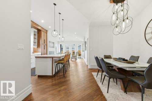 Open-concept dining and kitchen areas featuring wood-finish flooring, recessed lighting, and vaulted ceilings - 1 Sparrow Close, Fort Saskatchewan, AB - Indoor Photo Showing Dining Room