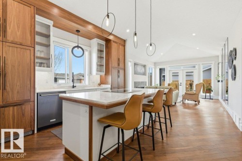 Open-concept kitchen featuring wood-finish cabinetry, a large center island with a light-toned countertop, and recessed lighting - 1 Sparrow Close, Fort Saskatchewan, AB - Indoor