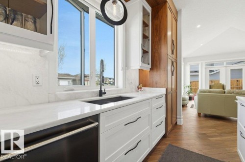 Kitchen featuring a large window, white countertops, built-in cabinetry, and a black sink with a matching faucet - 1 Sparrow Close, Fort Saskatchewan, AB - Indoor Photo Showing Other Room