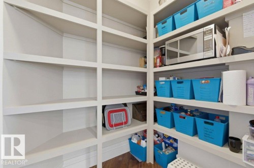Expansive pantry featuring extensive built-in shelving, ample storage capacity, a dedicated appliance shelf, and wood-finish flooring - 1 Sparrow Close, Fort Saskatchewan, AB - Indoor With Storage