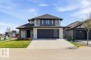 Contemporary two-story residence featuring a dark asphalt shingle roof, light-colored siding, and stacked stone accents - 1 Sparrow Close, Fort Saskatchewan, AB  - Outdoor With Facade 