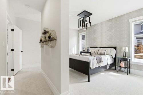 Bedroom featuring a contemporary ceiling fixture, patterned accent wall, and carpet flooring - 1 Sparrow Close, Fort Saskatchewan, AB - Indoor