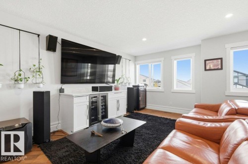 Living area featuring wood-finish flooring, recessed lighting, and multiple windows - 1 Sparrow Close, Fort Saskatchewan, AB - Indoor Photo Showing Living Room