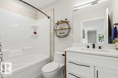 Bathroom featuring a white vanity with a marble-finish countertop, undermount sink, and matte black fixtures - 1 Sparrow Close, Fort Saskatchewan, AB - Indoor Photo Showing Bathroom