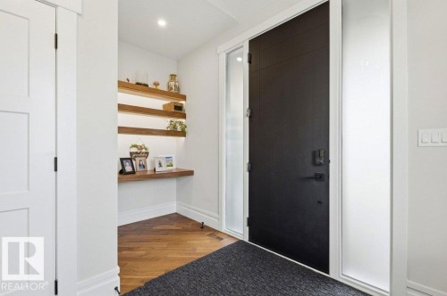 Modern entryway featuring a solid black door with matte black hardware, flanked by frosted glass side panels - 1 Sparrow Close, Fort Saskatchewan, AB - Indoor Photo Showing Other Room