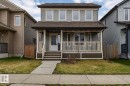 Two-story residence featuring light gray siding with white trim, a covered front porch, and a dark brown shingle roof - 17715 6 Avenue, Edmonton, AB  - Outdoor With Deck Patio Veranda 