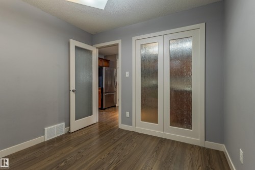 Room featuring wood-finish flooring, light gray wall paint, and white trim - 17715 6 Avenue, Edmonton, AB - Indoor Photo Showing Other Room