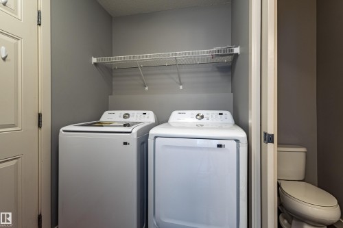 Laundry area featuring a top-load washer, front-load dryer, and overhead wire shelving - 17715 6 Avenue, Edmonton, AB - Indoor Photo Showing Laundry Room