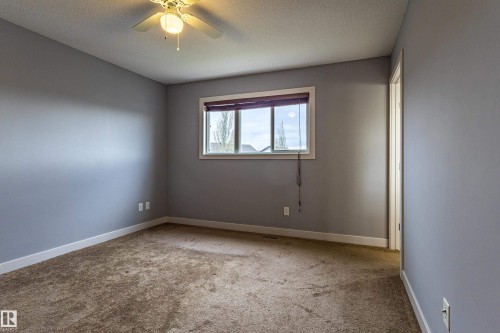 Carpeted interior room with light gray walls, white trim, and a ceiling fan with integrated lighting - 17715 6 Avenue, Edmonton, AB - Indoor Photo Showing Other Room