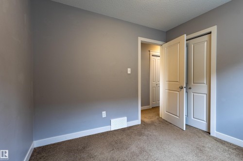 Interior room featuring gray painted walls, textured ceiling, and brown carpet flooring - 17715 6 Avenue, Edmonton, AB - Indoor Photo Showing Other Room
