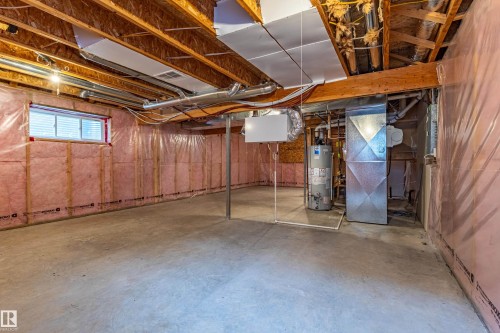 Unfinished basement featuring exposed wood joists, concrete flooring, a window with blinds, visible insulation, and essential utility infrastructure - 17715 6 Avenue, Edmonton, AB - Indoor Photo Showing Basement