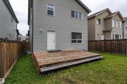 Private backyard featuring a wood deck and a level lawn area - 