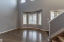 Open concept living area featuring dark wood-finish flooring and a bay window with multiple panes - 17715 6 Avenue, Edmonton, AB  - Indoor Photo Showing Other Room 