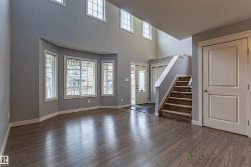 Two-story entry foyer with wood-finish flooring and a carpeted staircase - 17715 6 Avenue, Edmonton, AB - Indoor Photo Showing Other Room