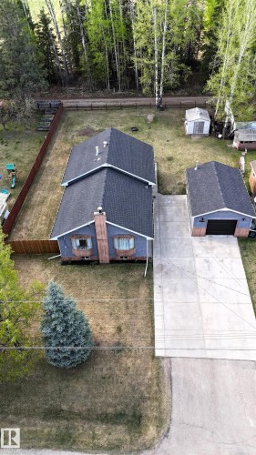 Two-story residence featuring a dark shingle roof, light blue siding, and a prominent brick-clad chimney - 7126 4A Ave, Edson, AB - Outdoor