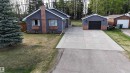 Exterior featuring gray siding, two prominent bay windows, and a detached single-car garage with a black door - 7126 4A Ave, Edson, AB  - Outdoor 