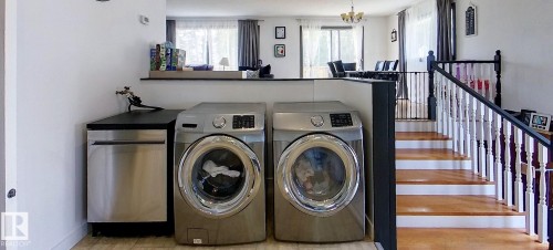 Integrated laundry area featuring stainless steel front-loading appliances and a built-in stainless steel dishwasher - 7126 4A Ave, Edson, AB - Indoor Photo Showing Laundry Room