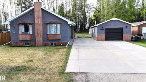 Grey stucco exterior featuring two bay windows with wood-finish accents - 7126 4A Ave, Edson, AB - Outdoor