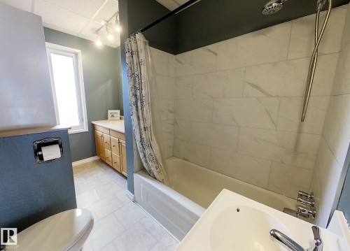 Tub-shower combination featuring white subway tile surround and a chrome shower head - 7126 4A Ave, Edson, AB - Indoor Photo Showing Bathroom