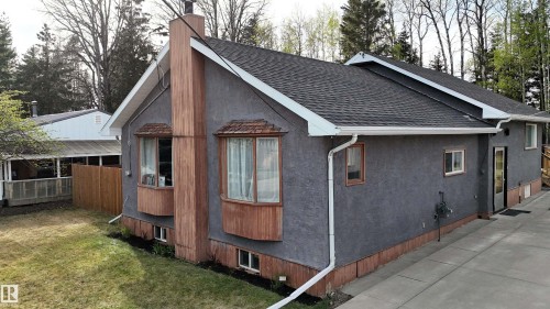 Stucco exterior with wood-finish trim and bay windows - 7126 4A Ave, Edson, AB - Outdoor With Exterior