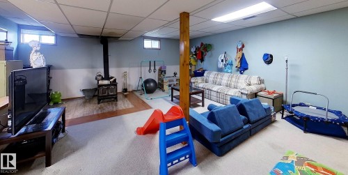 Spacious lower level featuring a wood-burning stove, recessed lighting, and a combination of carpet and wood-finish flooring - 7126 4A Ave, Edson, AB - Indoor Photo Showing Basement