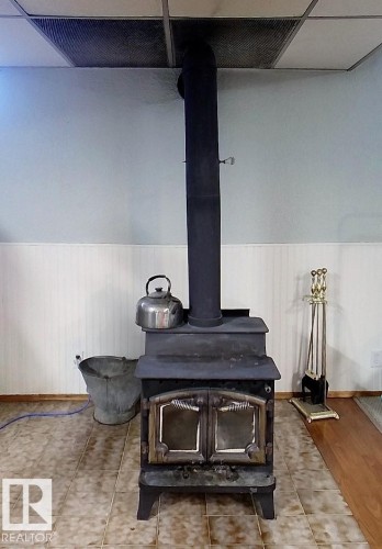 Cast iron wood-burning stove with dual glass doors - 7126 4A Ave, Edson, AB - Indoor Photo Showing Other Room