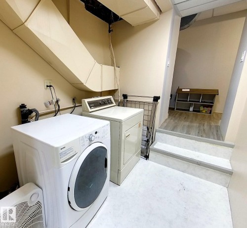Dedicated laundry area featuring a front-loading washing machine and dryer - 7126 4A Ave, Edson, AB - Indoor Photo Showing Laundry Room