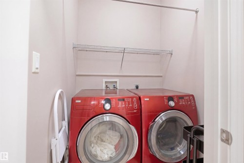Dedicated laundry area featuring dual front-loading appliances, a metal wire storage shelf, and an overhead clothes rod - 1444 37C Avenue, Edmonton, AB - Indoor Photo Showing Laundry Room