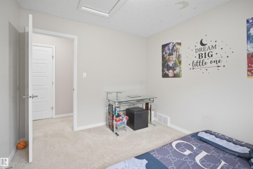 Carpeted room with a ceiling-mounted skylight and white trim - 1444 37C Avenue, Edmonton, AB - Indoor Photo Showing Bedroom